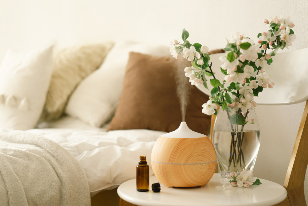 Wood-grain diffuser steaming beside a vase of blossoms