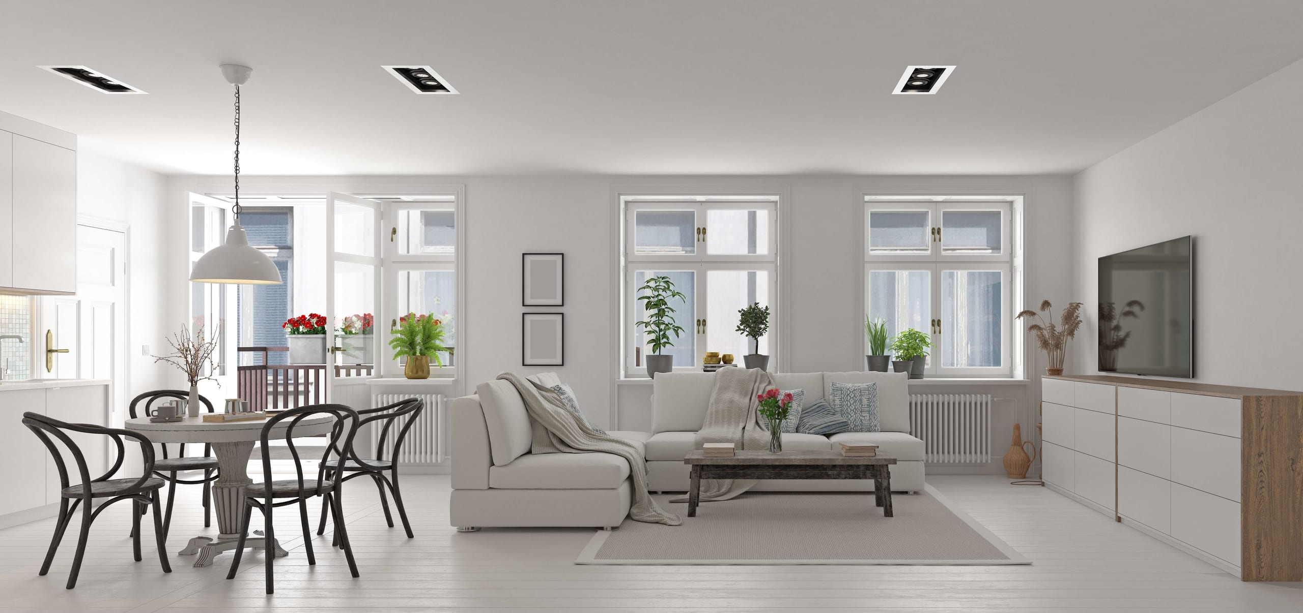 Bright white living and dining room with a sofa and round table