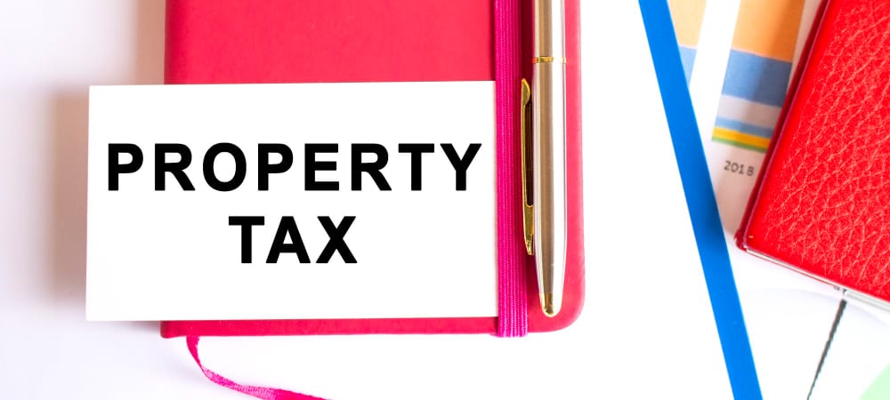 White card reading PROPERTY TAX on a red notebook