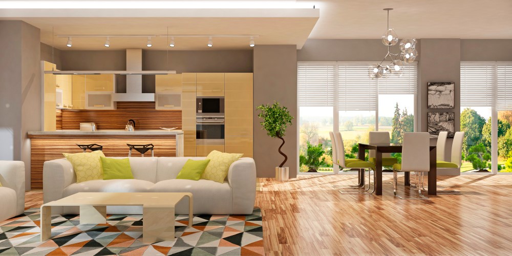 Staged open living room and kitchen with a white sofa and green pillows