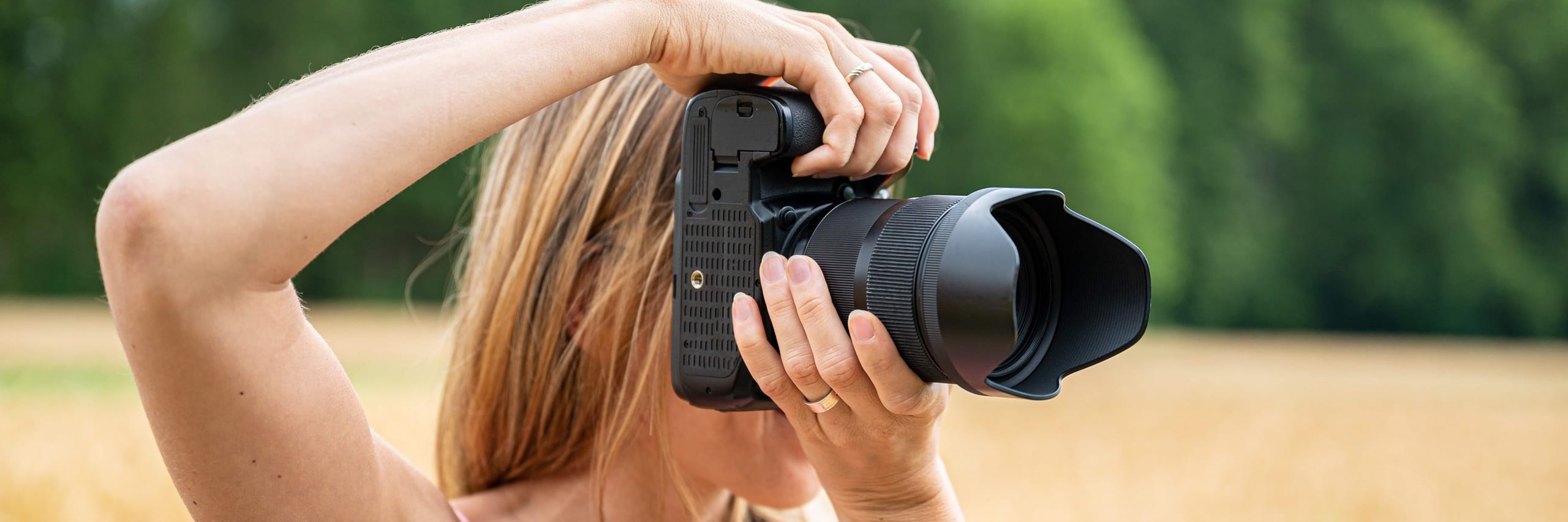 Woman photographing outdoors with a long lens