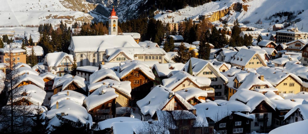 Snow-covered alpine village with a church steeple