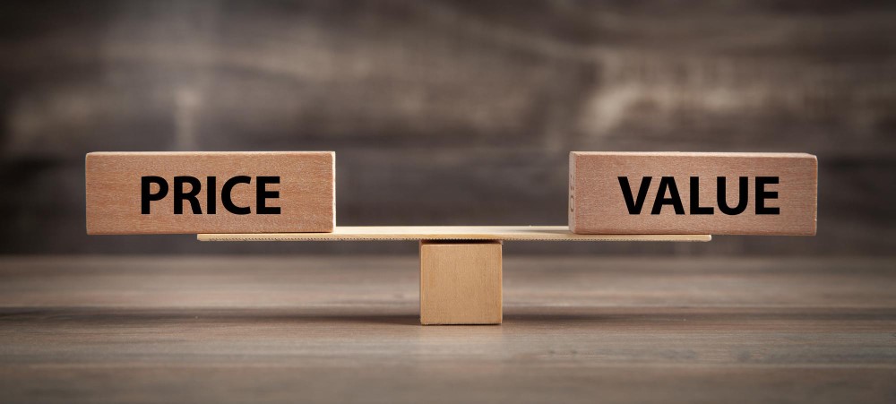Wooden blocks labeled Price and Value on a seesaw