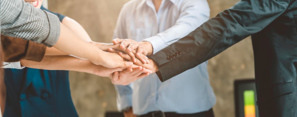 Several people stacking their hands in a huddle