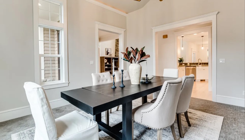 Staged dining room with a black table and white chairs