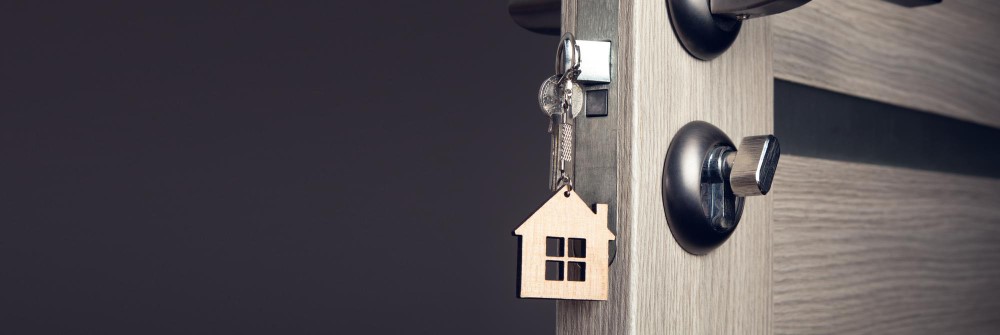 House-shaped keychain hanging from a door lock