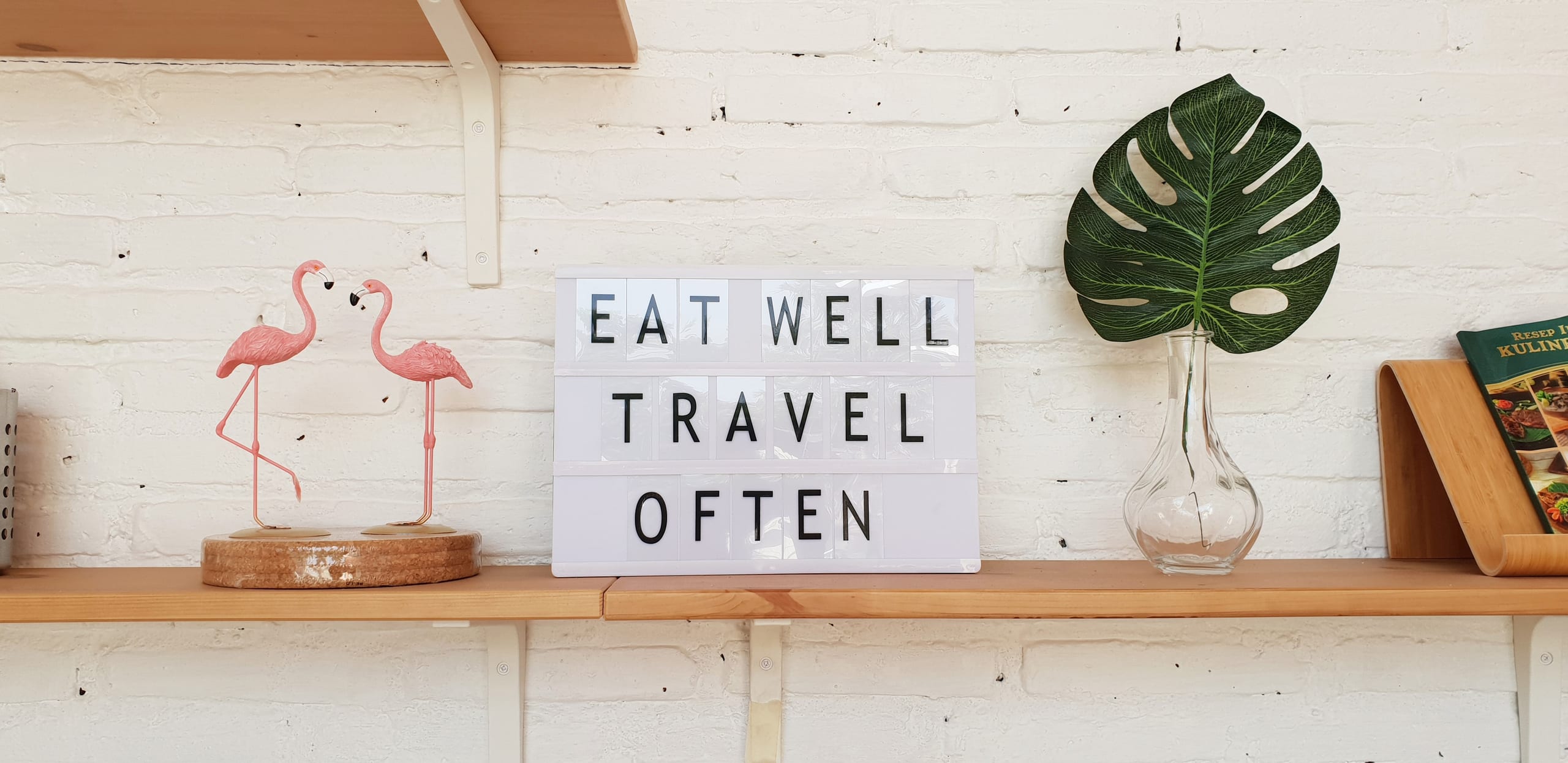 Shelf sign that reads Eat Well Travel Often