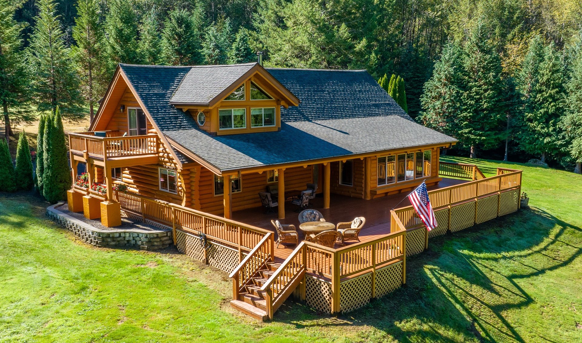 Log home with a wraparound deck in a forested clearing