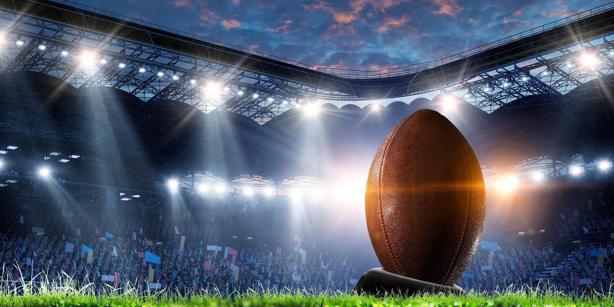 Football on a kicking tee in a lit stadium