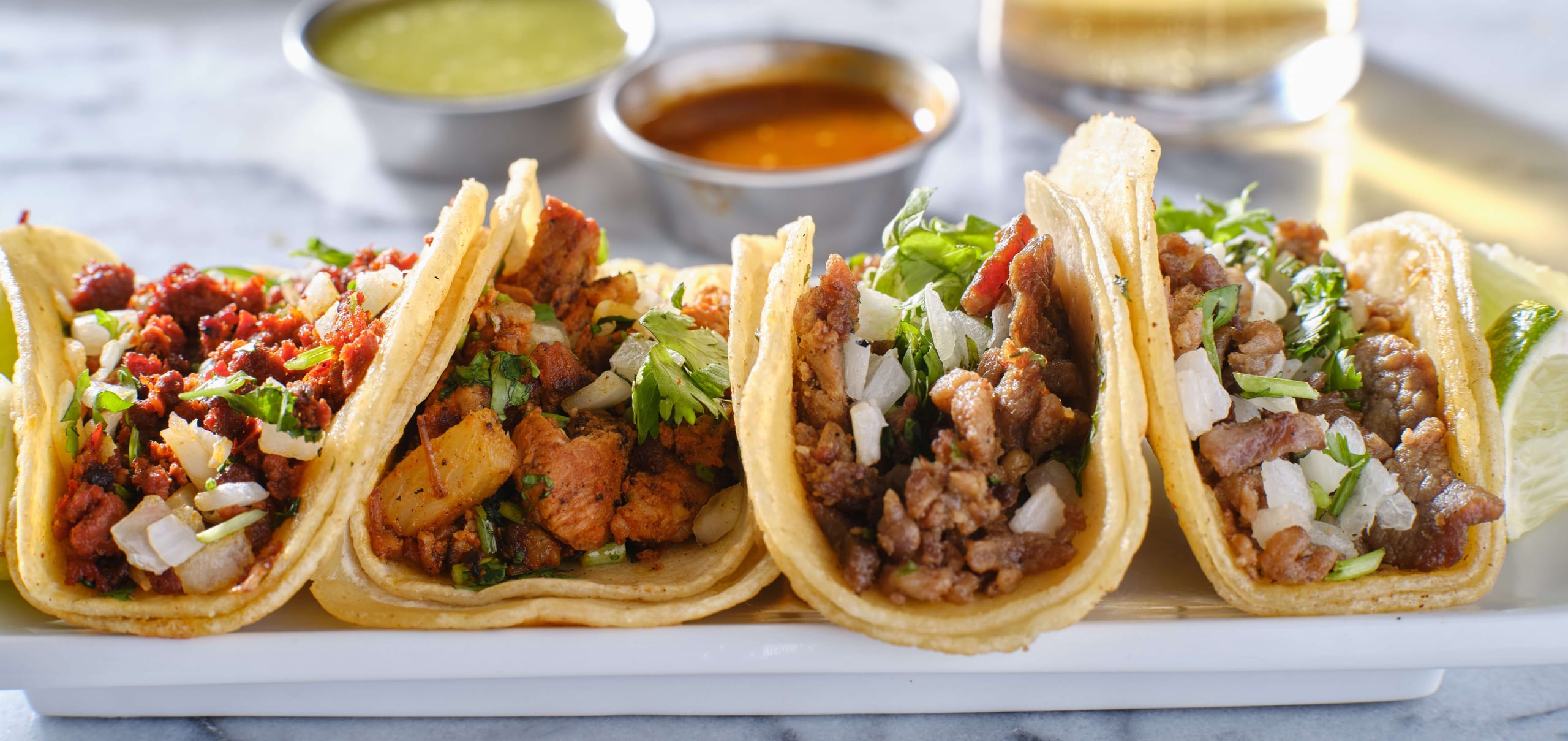 Platter of street tacos with salsa cups
