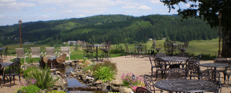Patio tables overlooking forested hills at Sweet Cheeks Winery